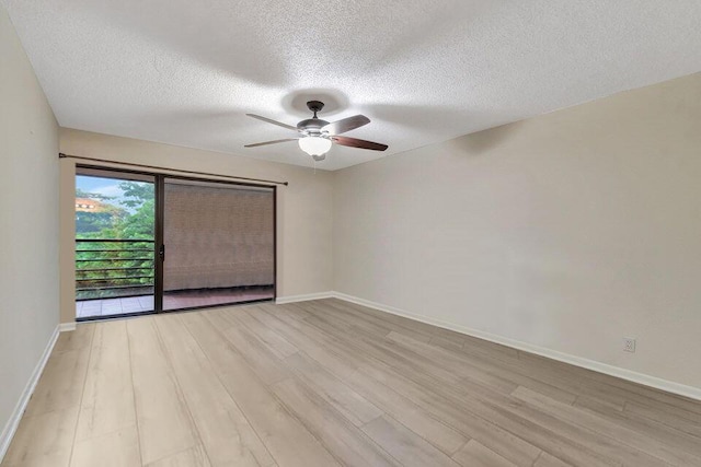 unfurnished room featuring ceiling fan, light wood-type flooring, and a textured ceiling