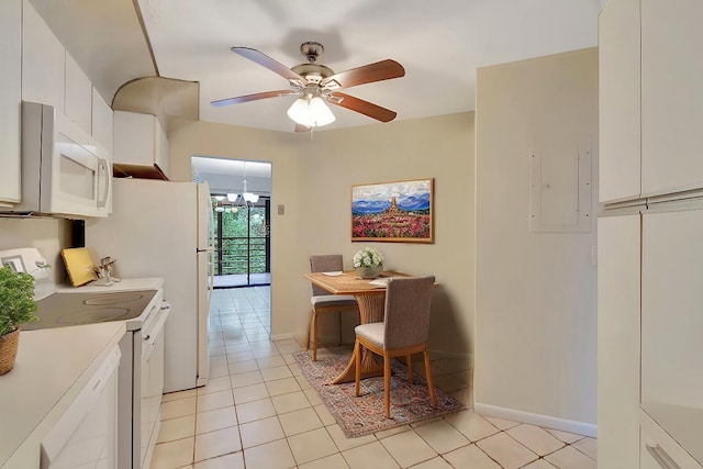 kitchen with white cabinetry, white appliances, light tile patterned floors, and ceiling fan with notable chandelier