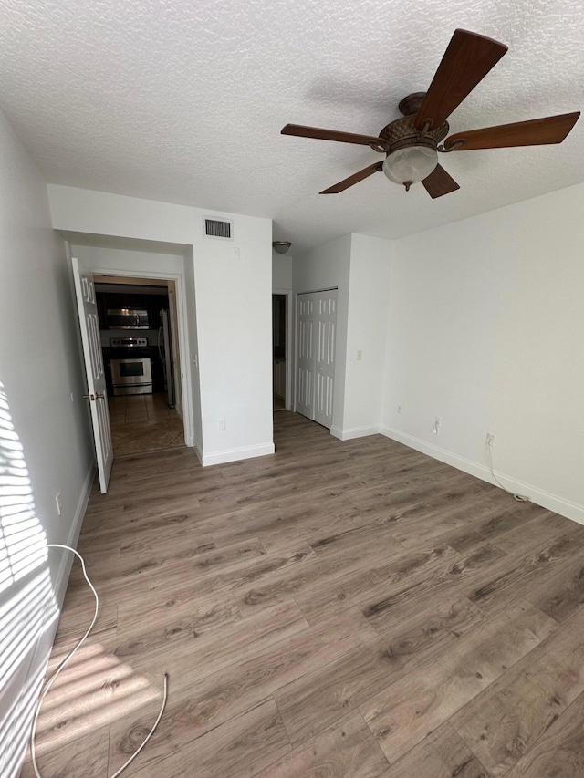 interior space featuring a textured ceiling, hardwood / wood-style flooring, and ceiling fan