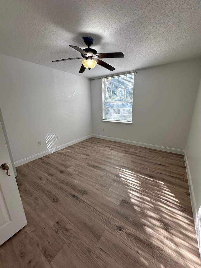 empty room featuring hardwood / wood-style floors, ceiling fan, and a textured ceiling