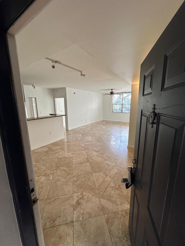 empty room featuring a textured ceiling and ceiling fan