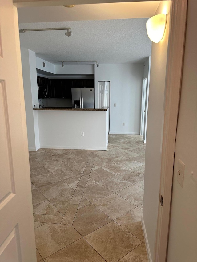 empty room featuring a textured ceiling and light tile patterned floors