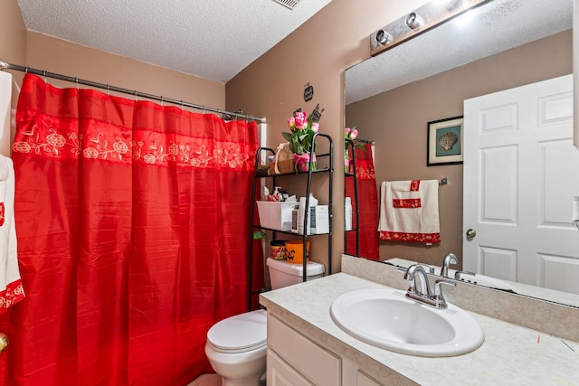 bathroom featuring toilet, vanity, and a textured ceiling