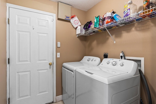 laundry area with a textured ceiling and washer and clothes dryer