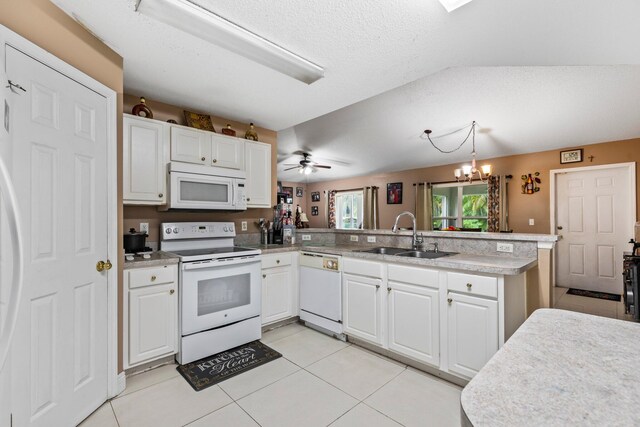 kitchen featuring sink, white appliances, white cabinetry, and kitchen peninsula