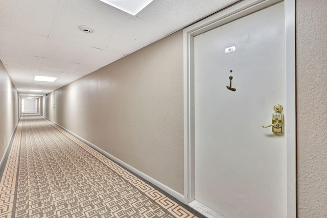 hallway with tile patterned floors and baseboards