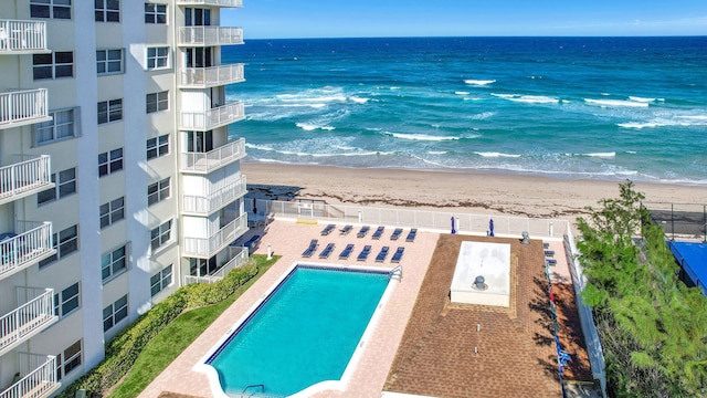 community pool with a water view and a view of the beach