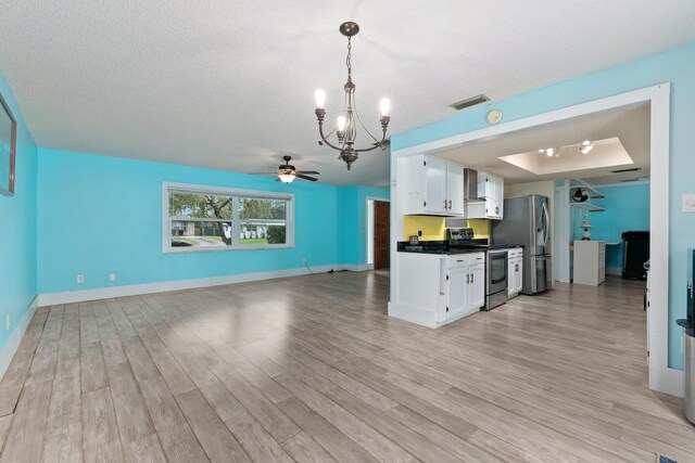 kitchen featuring light wood-type flooring, white cabinets, a textured ceiling, and stainless steel appliances