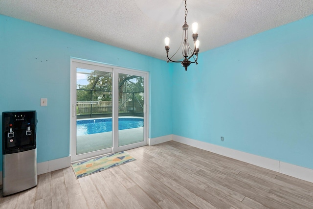 empty room with light hardwood / wood-style floors and a textured ceiling