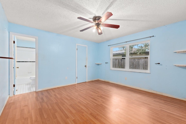 empty room featuring ceiling fan, a textured ceiling, and light wood-type flooring