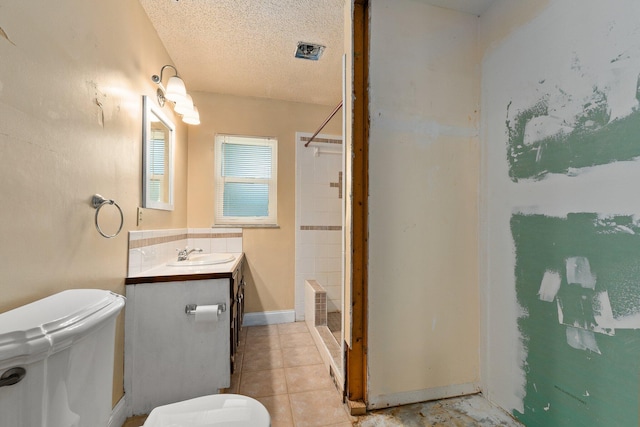 bathroom with vanity, tile patterned flooring, a textured ceiling, and toilet