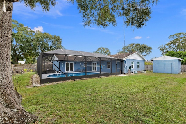 rear view of property with a storage shed, glass enclosure, a fenced in pool, and a yard