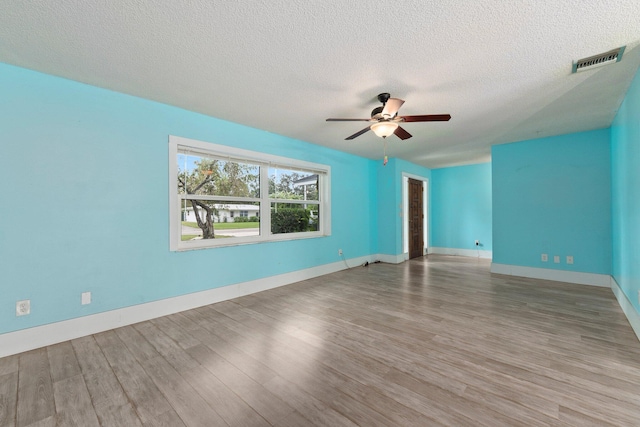 spare room with wood-type flooring, ceiling fan, and a textured ceiling