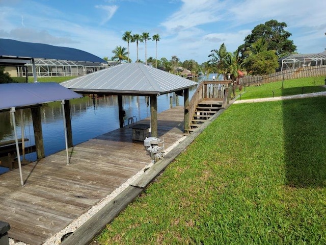 dock area with a lawn and a water view