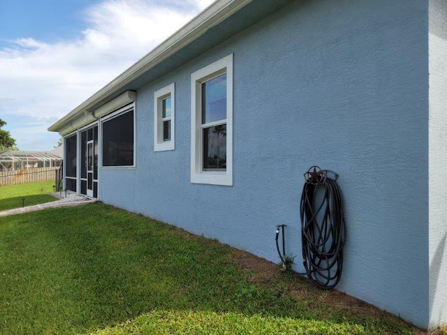 view of side of property with a yard and stucco siding