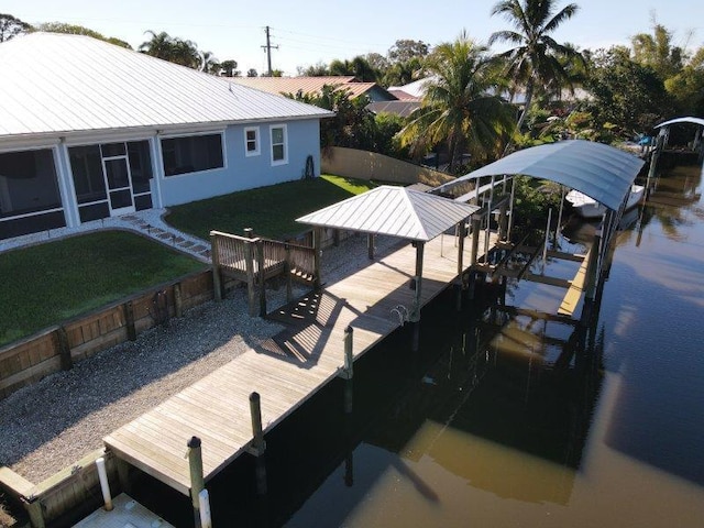 dock area featuring boat lift, a yard, and a water view