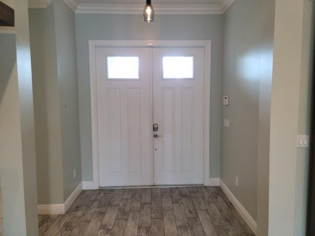 entryway featuring baseboards, wood finished floors, and ornamental molding