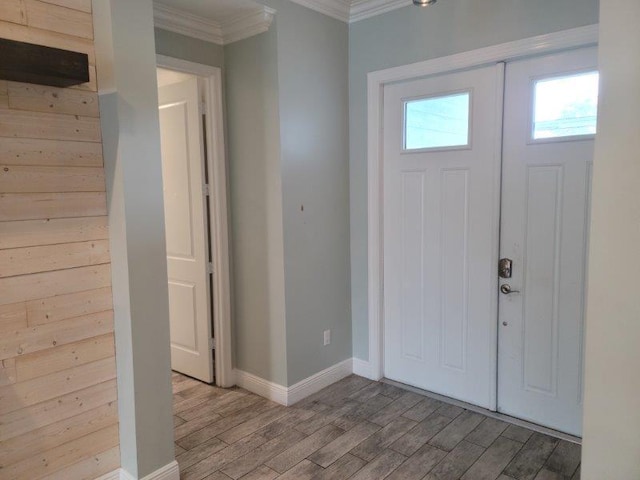 entryway featuring baseboards, light wood-style flooring, and crown molding