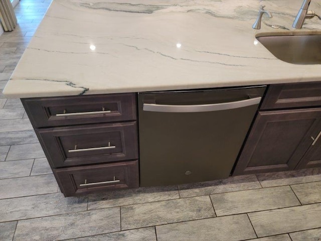 room details featuring a sink, dark brown cabinets, and stainless steel dishwasher