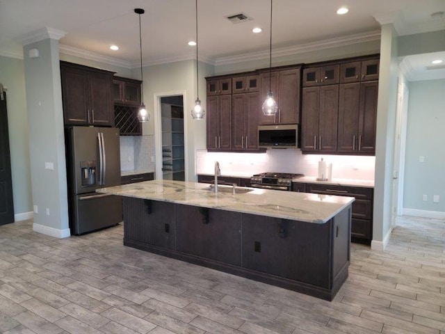 kitchen with a sink, backsplash, stainless steel appliances, light wood-style floors, and dark brown cabinetry