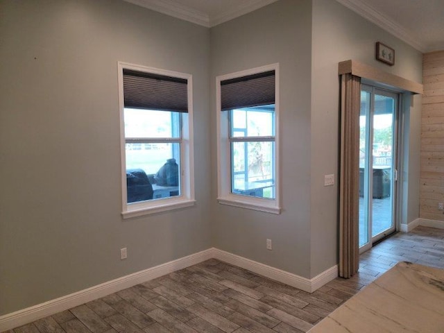 spare room featuring baseboards, wood finished floors, and ornamental molding