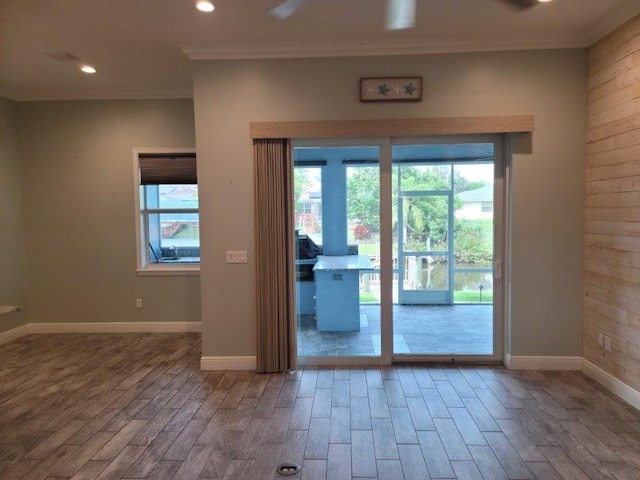 entryway with crown molding, wood finished floors, and baseboards