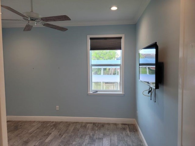 empty room with wood finished floors, baseboards, recessed lighting, ceiling fan, and ornamental molding