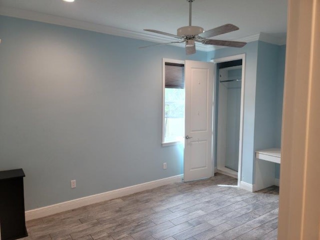 unfurnished bedroom featuring light wood-style floors, baseboards, a closet, and ornamental molding