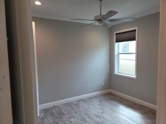 empty room featuring baseboards, light wood-style floors, and ornamental molding