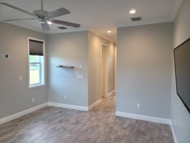 empty room with visible vents, crown molding, baseboards, recessed lighting, and light wood-style floors