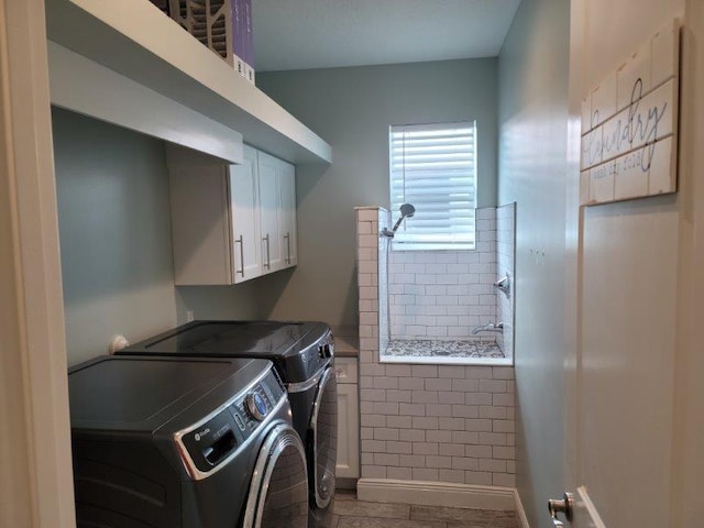 washroom with cabinet space and separate washer and dryer