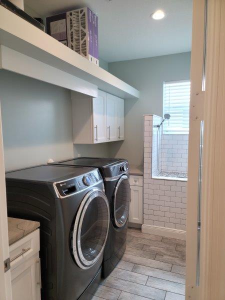 clothes washing area featuring washer and dryer, cabinet space, and wood tiled floor