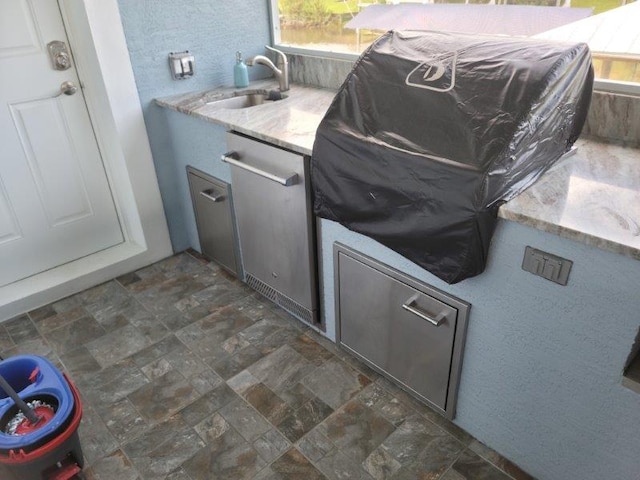 view of patio with an outdoor kitchen and a sink