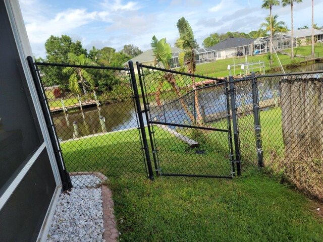 view of gate with a lawn and fence