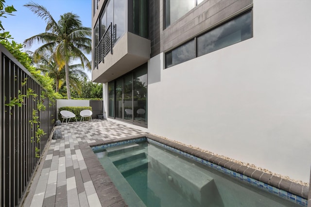 view of pool with a jacuzzi and a patio