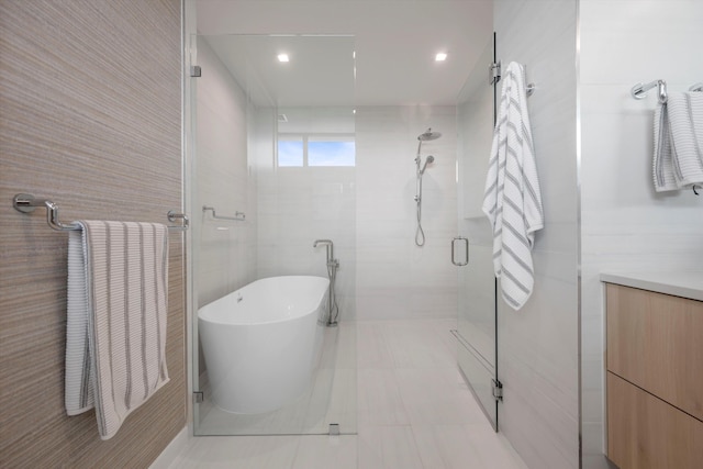 bathroom featuring tile patterned floors, vanity, separate shower and tub, and tile walls