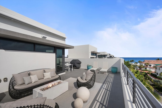 view of patio with a water view, a balcony, grilling area, and an outdoor living space with a fire pit