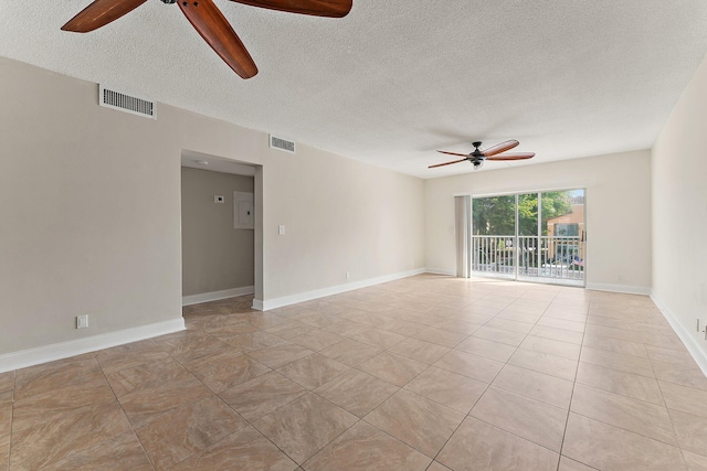 empty room with a textured ceiling, ceiling fan, and light tile patterned flooring