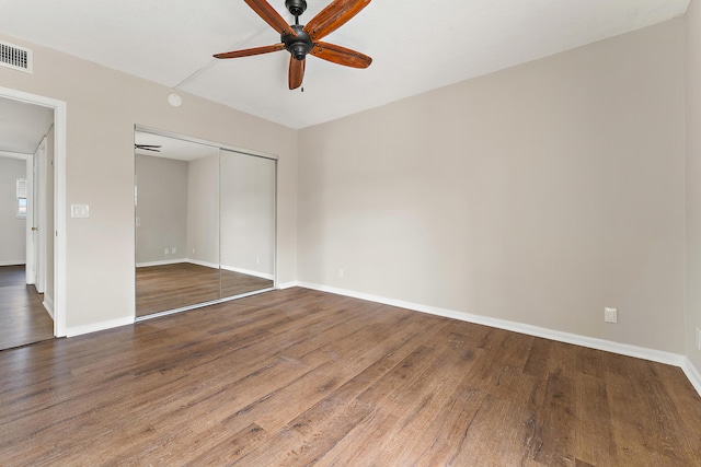 unfurnished bedroom featuring hardwood / wood-style floors, a closet, and ceiling fan