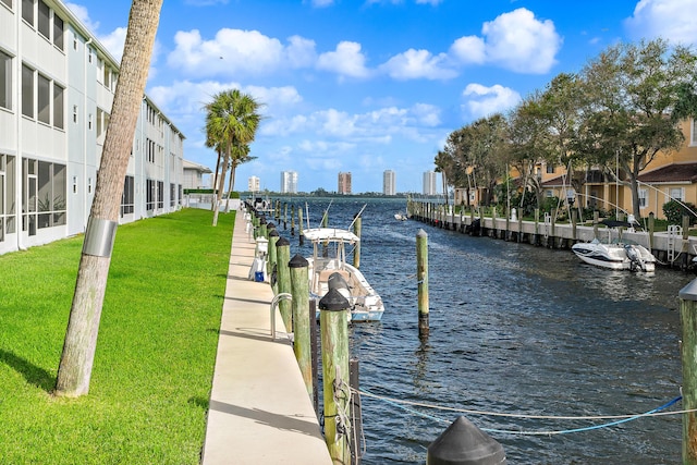 view of dock featuring a water view and a yard