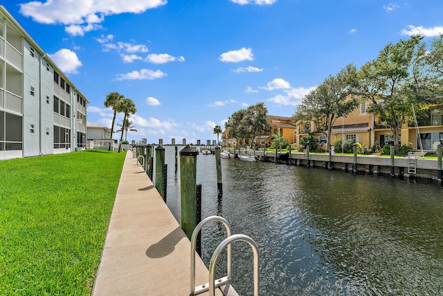 dock area with a lawn and a water view