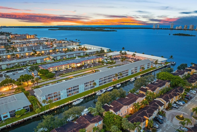 aerial view at dusk featuring a water view