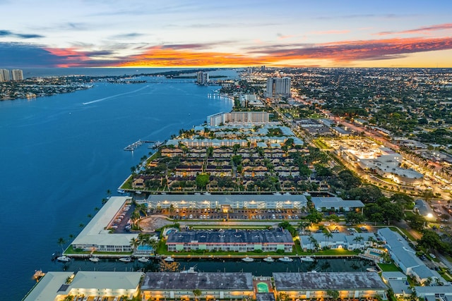 aerial view at dusk featuring a water view