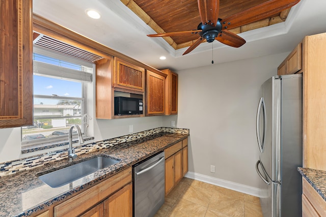 kitchen with dark stone countertops, ceiling fan, sink, and appliances with stainless steel finishes