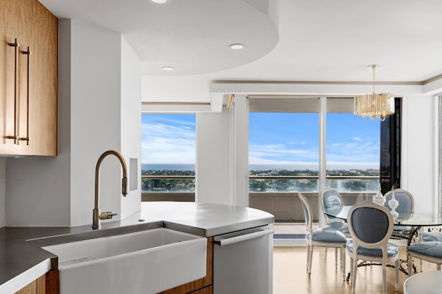 kitchen featuring sink, decorative light fixtures, stainless steel dishwasher, and a chandelier