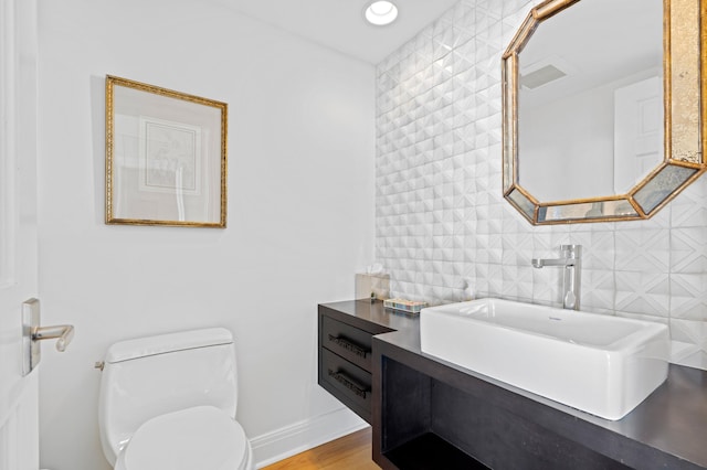 bathroom featuring vanity, hardwood / wood-style flooring, and toilet