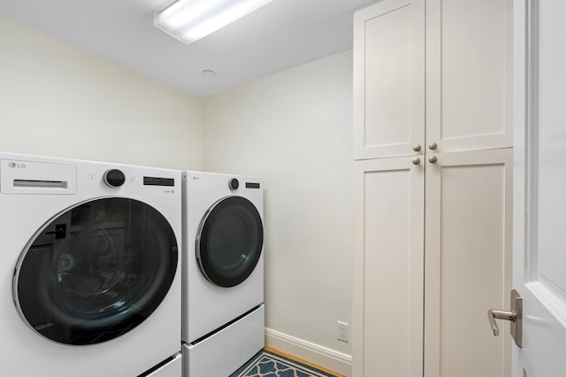 clothes washing area featuring cabinets and independent washer and dryer