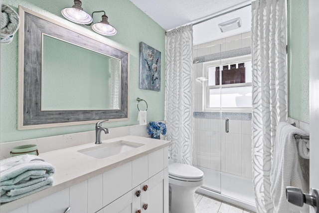 bathroom featuring tiled shower, a textured ceiling, vanity, and toilet