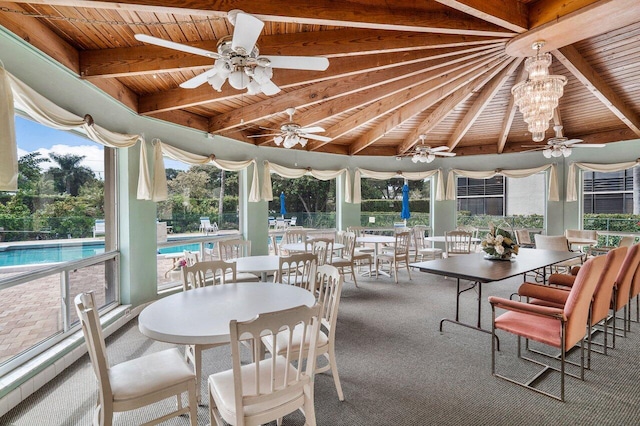 sunroom / solarium featuring ceiling fan, plenty of natural light, and wood ceiling