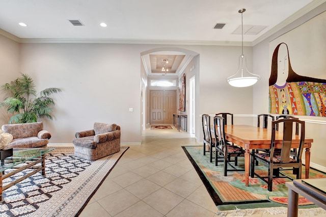 tiled dining room with a raised ceiling and crown molding